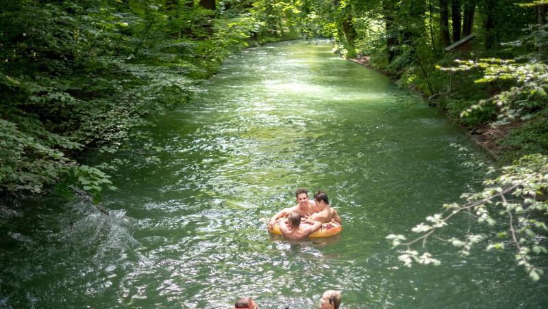 Münchner schwimmen bei warmen Temperaturen durch einen Bach im Englischen Garten. Foto: Sina Schuldt/Archiv Münchner schwimmen bei warmen Temperaturen durch einen Bach im Englischen Garten. Foto: Sina Schuldt/Archiv