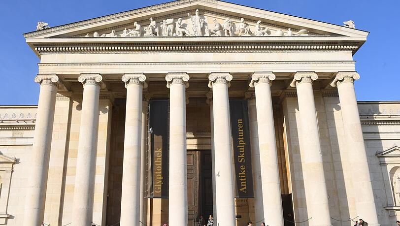 Viele Sonnenhungrige sitzen am Königsplatz vor der Glyptothek in der Sonne und genießen den Tag.