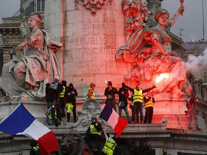 Demonstranten zünden während des Protests der "Gelbwesten" auf dem Platz der Republik Pyrotechnik.