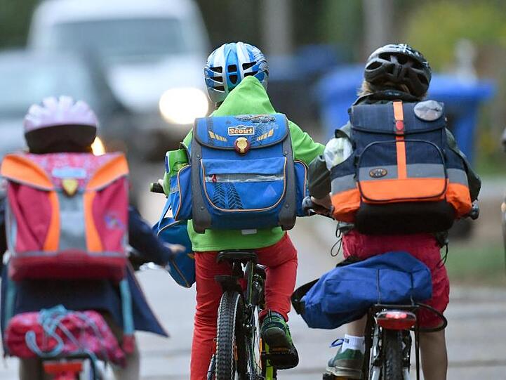 Kinder sind mit dem Fahrrad unterwegs zur Schule.