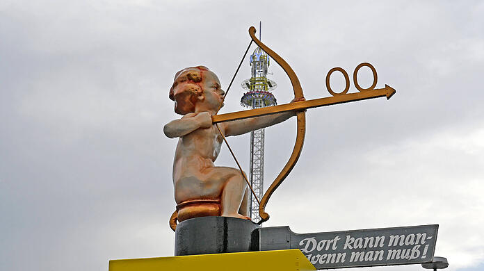 "Dort kann man, wenn man muß": Dieser Wegweiser auf der Wiesn führt zur nächsten Toilette.