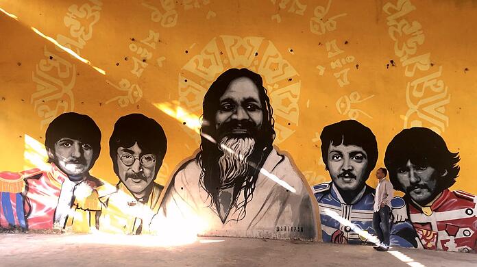 Suchbild mit Autor: Daniel Speck im ehemaligen Ashram des Maharishi, in dem auch die Beatles 1968 Zeit verbrachten. Heute sind sie dort auf zahlreichen Graffitis verewigt.