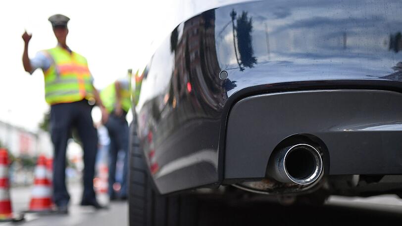 Polizisten kontrollieren ein getuntes Auto.