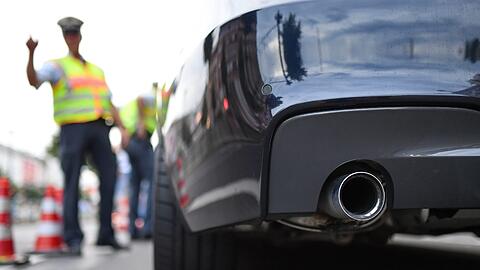 Polizisten kontrollieren ein getuntes Auto.