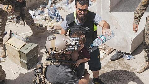 Auf diesem vom US Marine Corps zur Verfügung gestellten Foto trägt ein US-Soldat ein Kind an einem Evakuierungskontrollpunkt am Kabuler Flughafen.
