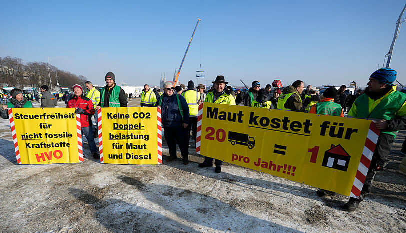 Teilnehmer mit Transparenten beteiligen sich an einer Protestkundgebung von Transport- und Spediteursverbänden gegen die Klima- und Abgabenpolitik der Bundesregierung auf der Theresienwiese.