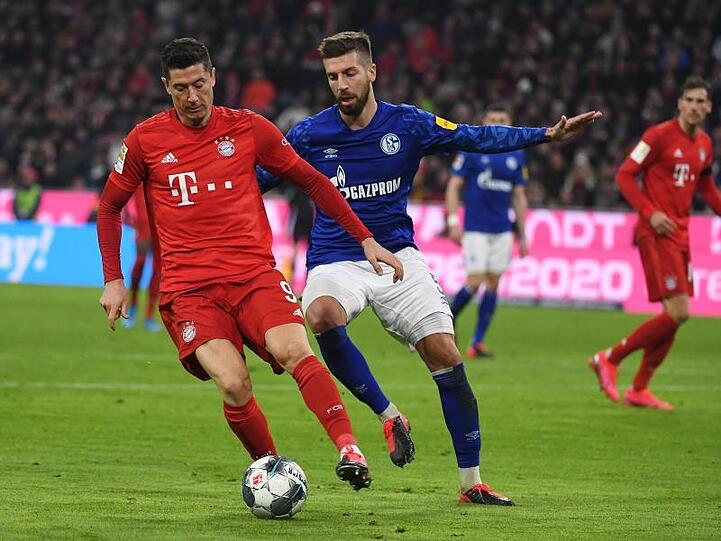 Bayerns Lewandowski kämpft mit Schalkes Nastasic um den Ball. Foto: Angelika Warmuth/dpa/Archivbild