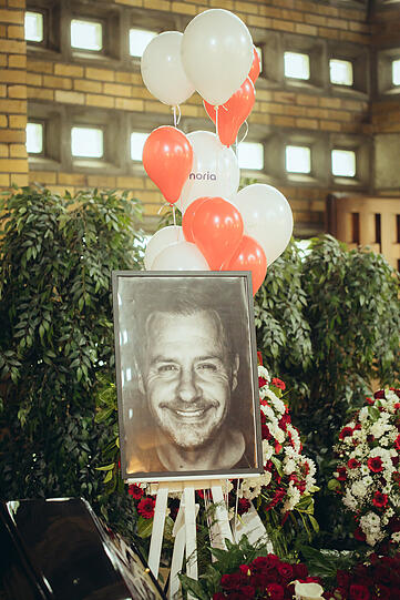Ein Schwarz-Weiß-Bild von Willi Herren mit rot-weißen Luftballons
