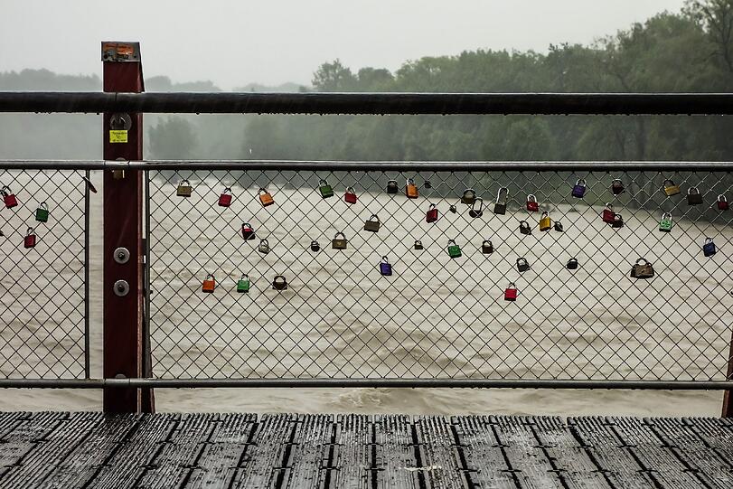 Der Blick durch die Schlösser an der Thalkirchner Brücke auf die Isar.