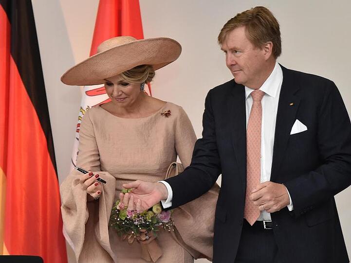 König Willem-Alexander reicht Königin Maxima den Stift für die Eintragung in das Goldene Buch der Staatskanzlei.