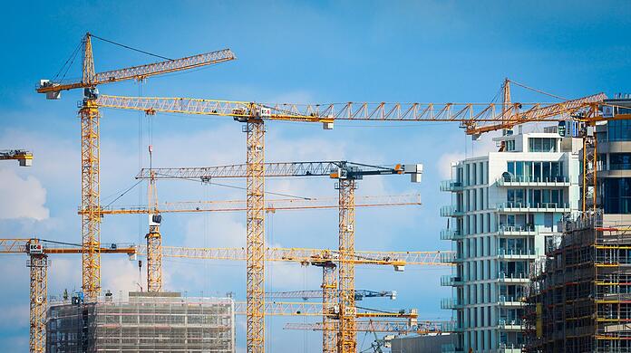 Baukräne stehen auf einer Baustelle in einer Innenstadt.