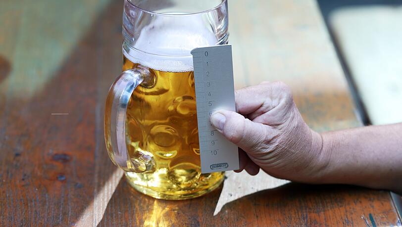 Mit einem geeichten Messstab kontrolliert Meier, wie voll die Maßen auf der Wiesn sind. Bei 15 Millimeter unter dem Eichstrich spricht man von "Unterschank".