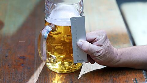 Mit einem geeichten Messstab kontrolliert Meier, wie voll die Maßen auf der Wiesn sind. Bei 15 Millimeter unter dem Eichstrich spricht man von "Unterschank".