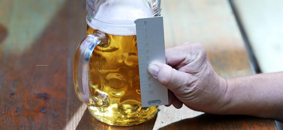 Mit einem geeichten Messstab kontrolliert Meier, wie voll die Maßen auf der Wiesn sind. Bei 15 Millimeter unter dem Eichstrich spricht man von "Unterschank".