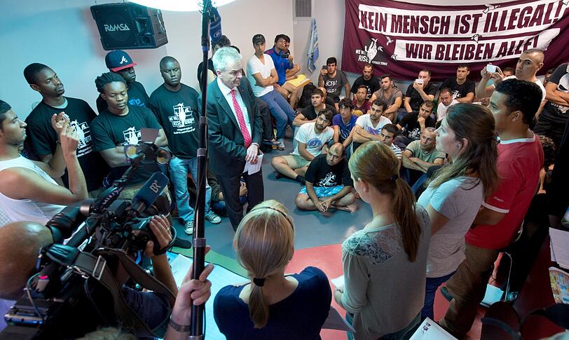 2013: DGB-Chef Matthias Jena spricht im Keller des Hauses zu Geflüchteten.