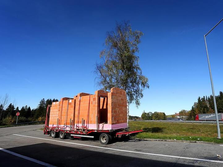 Ein Anhänger mit zwei gemauerten Toilettenhäuschen steht auf einem Parkplatz der Autobahn A7. Foto: Karl-Josef Hildenbrand/dpa