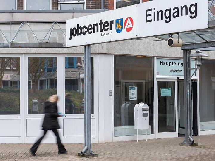 Eine Frau geht in ein Jobcenter der Agentur für Arbeit. Foto: Daniel Bockwoldt/dpa/Archivbild