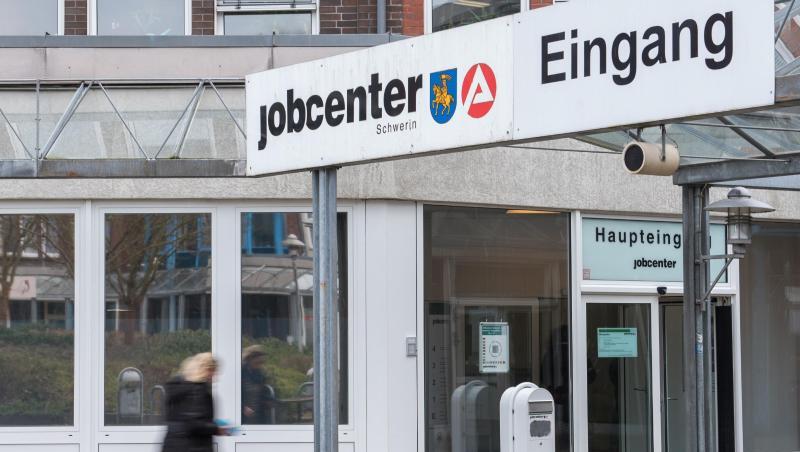 Eine Frau geht in ein Jobcenter der Agentur für Arbeit. Foto: Daniel Bockwoldt/dpa/Archivbild