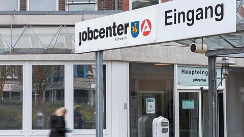Eine Frau geht in ein Jobcenter der Agentur für Arbeit. Foto: Daniel Bockwoldt/dpa/Archivbild