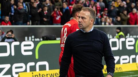 Münchens Trainer Hansi Flick bei den eigenen Fans, nachdem diese ein beleidigendes Banner präsentiert haben. Foto: Tom Weller/dpa