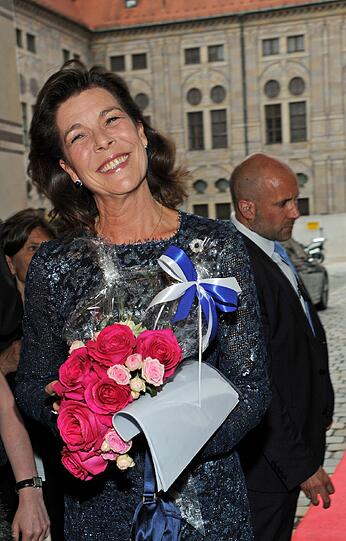 Einmal lächeln, bitte: Prinzessin Caroline bekam einen Strauß pinke Rosen überreicht.