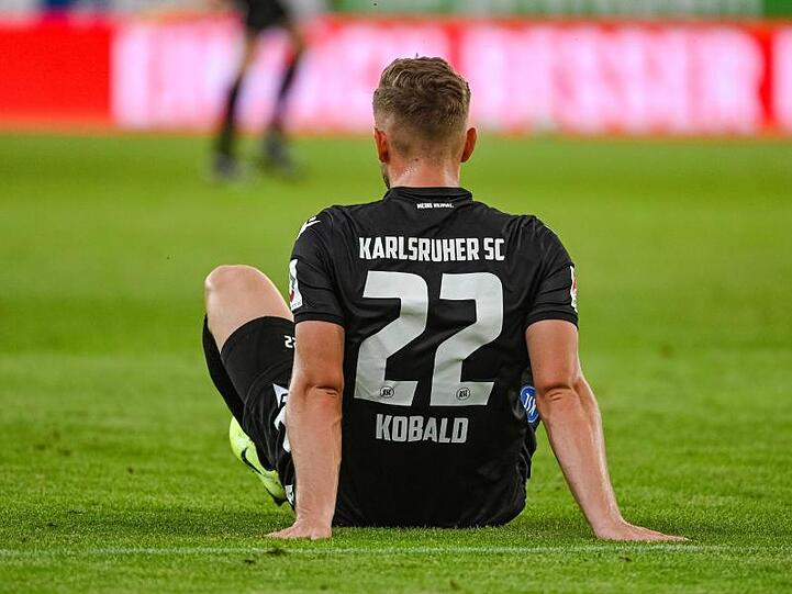 Christoph Kobald sitzt nach dem mit 2:1 verlorenen Spiel gegen Regensburg enttäuscht auf dem Rasen. Foto: Armin Weigel/dpa