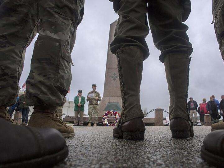 US-Soldaten und Besucher stehen an einem Denkmal an einem Strand, der bei der Landung der Alliierten den Decknamen "Utah Beach" bekam.