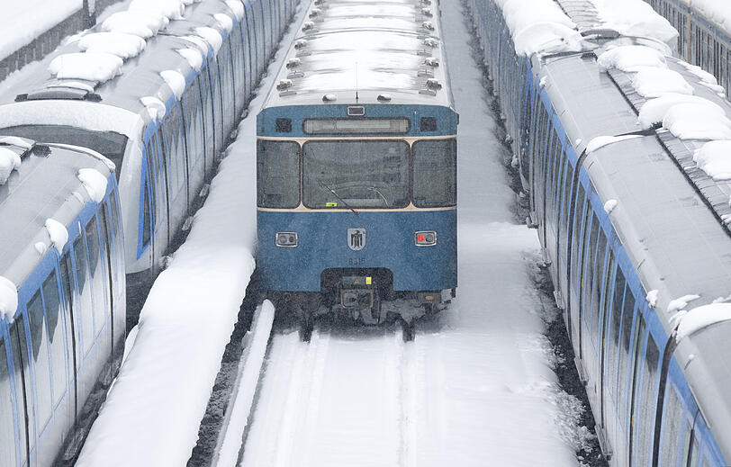 U-Bahnen der Münchner Verkehrsgesellschaft (MVG) stehen am U-Bahnhof Fröttmaning im Schnee.
