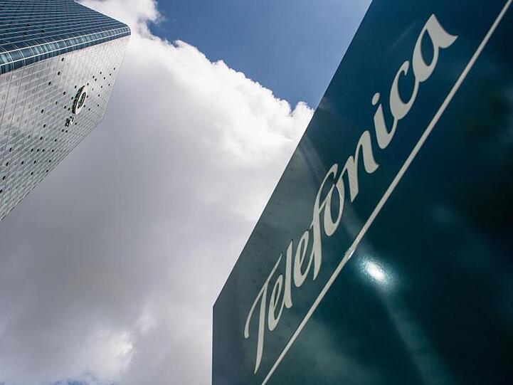 Das Logo von Telefonica ist auf einem Schild vor dem O2-Hochhaus zu sehen. Foto: Lino Mirgeler/Archivbild