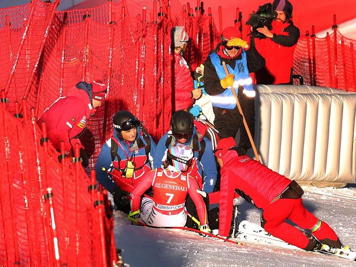 Viktoria Rebensburg (M) aus Deutschland sitzt nach ihrem Sturz neben dem Fangzaun. Foto: Karl-Josef Hildenbrand/dpa