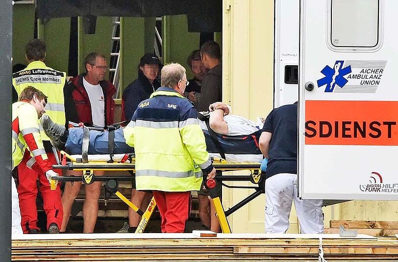 Mit Halskrause wird der verletzte Arbeiter vom Krankenwagen abtransportiert.