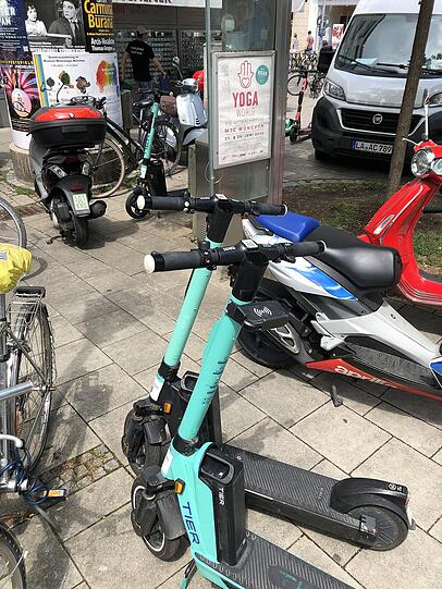 E-Scooter neben Rollern und Fahrrädern am Viktualienmarkt.
