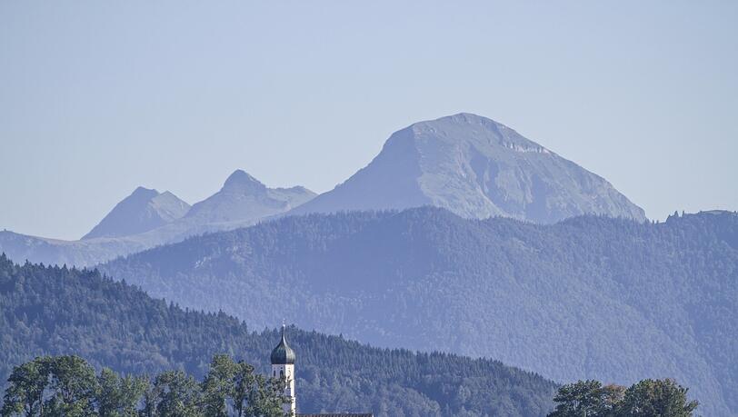 Der Kirchturm von Gaißach bei Tölz im Isartal mit dem gewaltigen Klotz des Juifen im Hintergrund. Der Kirchturm von Gaißach bei Tölz im Isartal mit dem gewaltigen Klotz des Juifen im Hintergrund.