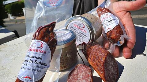 Günther Schlegel präsentiert verschiedene seiner Wurstprodukte, die mit Frankenwein hergestellt wurden. Foto: Karl-Josef Hildenbrand/dpa/Archivbild