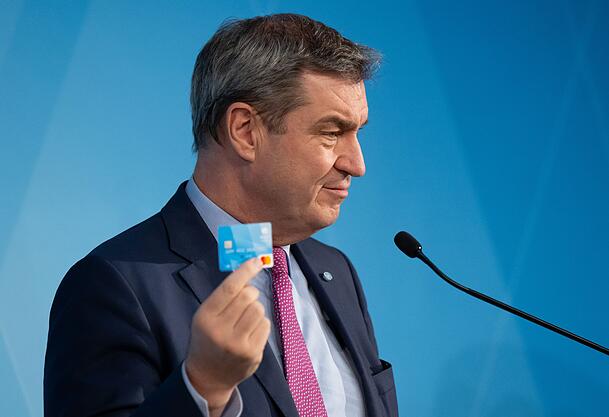 Markus Söder (CSU) hält die Bezahlkarte für Asylbewerber hoch. Bayern war das erste Bundesland, das die Karte eingeführt hat. Markus Söder (CSU) hält die Bezahlkarte für Asylbewerber hoch. Bayern war das erste Bundesland, das die Karte eingeführt hat.