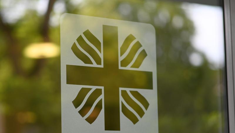 Das Logo der Caritas ist auf einer Glastür angebracht. Foto: Patrick Seeger/Archivbild Das Logo der Caritas ist auf einer Glastür angebracht. Foto: Patrick Seeger/Archivbild
