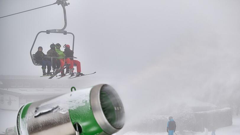 Wintersportler sind über einer künstlich beschneiten Piste an der Remmerswiese im Skilift unterwegs.
