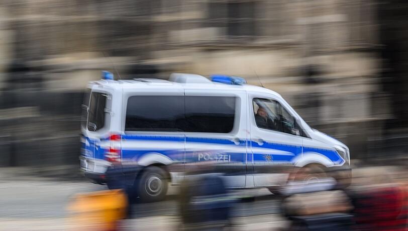 Ein Einsatzwagen der Polizei fährt durch eine Stadt.