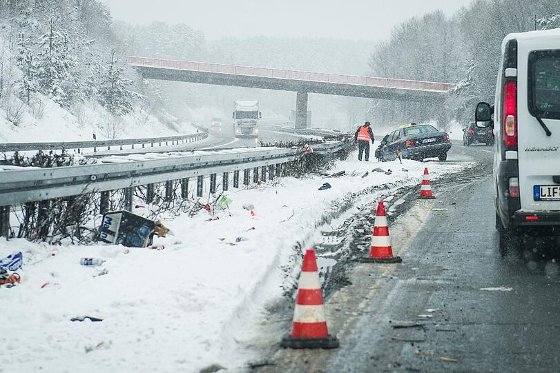 Ein Pkw steht auf der A70 bei Schirradorf (Bayern) nach einem Unfall auf schneebedeckter Fahrbahn an der Leitplanke.