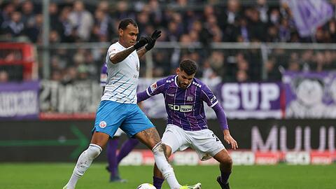 Der Rostocker Júnior Brumado (l) behauptet den Ball gegen Dave Gnaase.