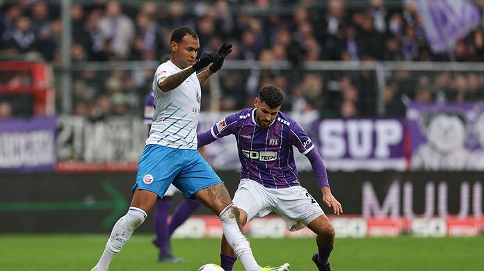 Der Rostocker Júnior Brumado (l) behauptet den Ball gegen Dave Gnaase.