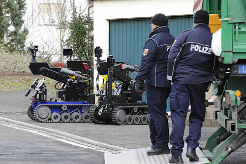 Sprengstoffroboter des Bundeskriminalamtes stehen am Samstag vor einem Haus in Becherbach.