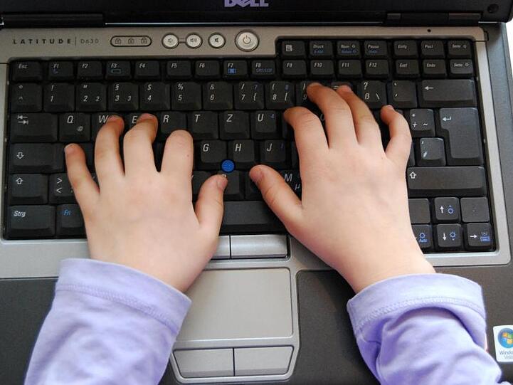 Ein Kind benutzt einen Laptop. Foto: picture alliance / dpa/Symbolbild