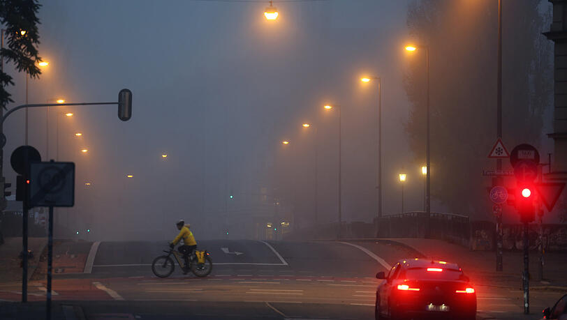 Über der Isar, auf der Corneliusbrücke, hängt eindrücklich die Suppe. Straßenlaternen und Rücklichter sorgen für besondere Effekte.