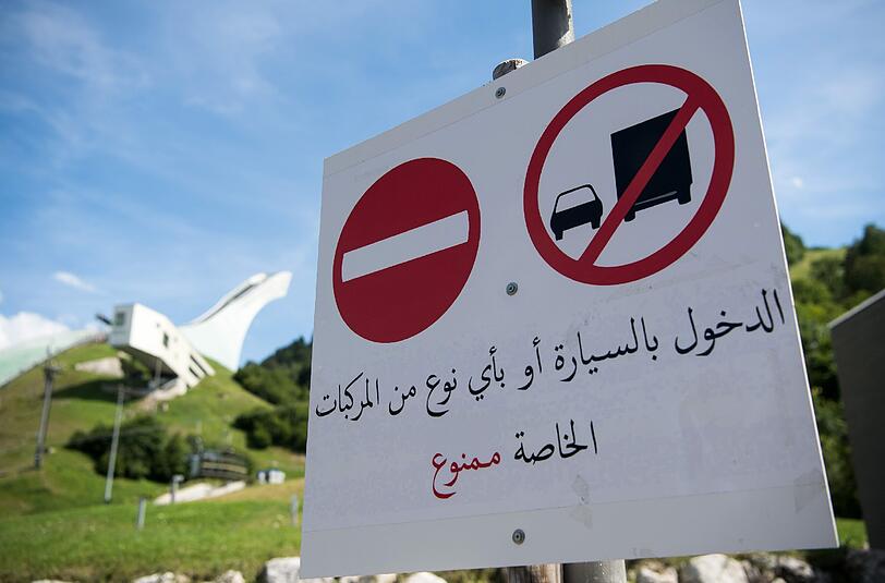 "Durchfahrt verboten": Das Schild unterhalb der Skisprungschanze wird auf Arabisch erklärt. Foto: Peter Kneffel