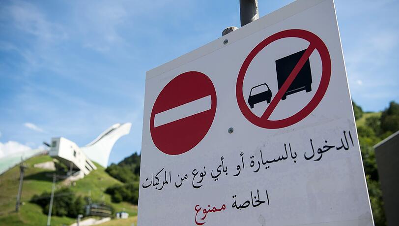 "Durchfahrt verboten": Das Schild unterhalb der Skisprungschanze wird auf Arabisch erklärt. Foto: Peter Kneffel "Durchfahrt verboten": Das Schild unterhalb der Skisprungschanze wird auf Arabisch erklärt. Foto: Peter Kneffel