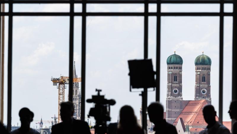 Journalisten warten während der Sitzung des bayerischen Landtags am Fenster vor der Kulisse Münchens. Foto: Peter Kneffel/Archivbild