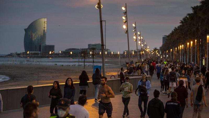 Menschen gehen bei Sonnenuntergang auf einer Strandpromenade spazieren und treiben Sport. Menschen gehen bei Sonnenuntergang auf einer Strandpromenade spazieren und treiben Sport.