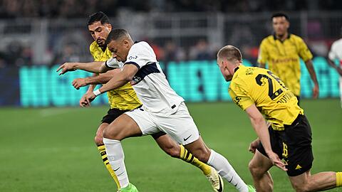 PSG-Superstar Kylian Mbappé (M) im Laufduell mit Emre Can (l) und Julian Ryerson.