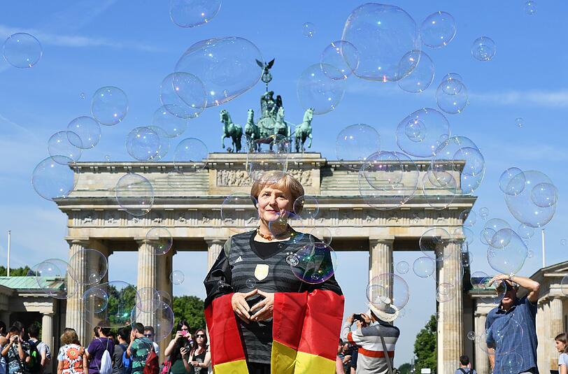 Angela Merkel im Deutschlandtrikot vor dem Brandenburger Tor - leider nur als Wachsfigur. Die Bilder!